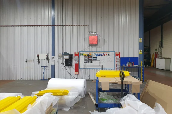 a X-heat heater is mounted on the wall, it is above a whiteboard and turned on.