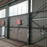 a grey walls with ridges on it that has 4 x-heat heaters on it, they are spread apart.